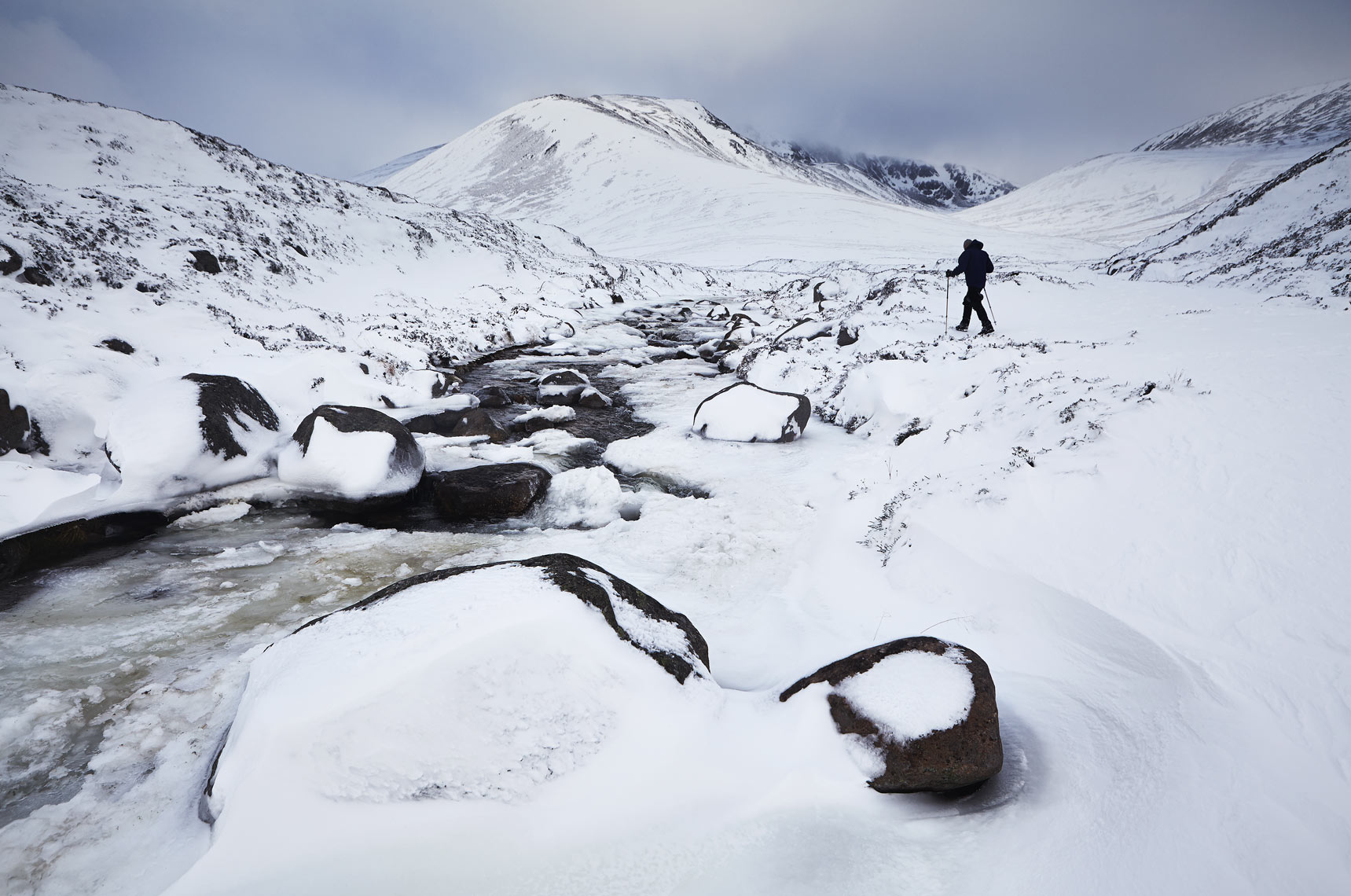 Lone hiker by frozen stream